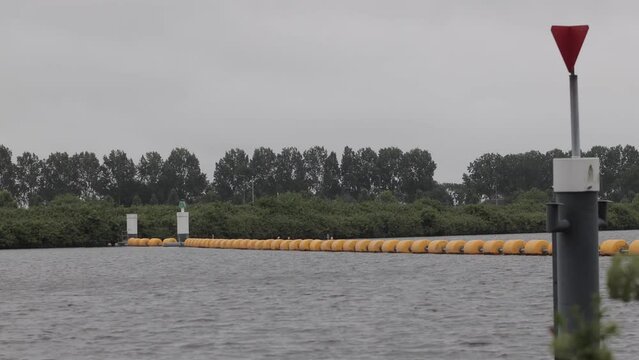Calm river with buoys during grey weather