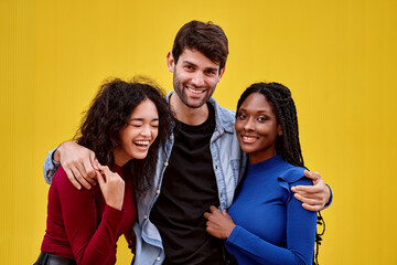 Three friends embracing and smiling while posing together. Friendship concept.