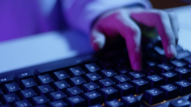 Close up boy using keyboard to play video game. Boy's fingers pressing keys on computer keyboard. e-sport video illustration.