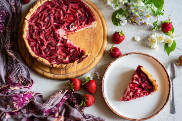 Sweet dessert for the whole family: strawberry pie. Strawberry tart on a large plate and a piece of pie on a plate. Strawberry dessert for breakfast. Close-up
