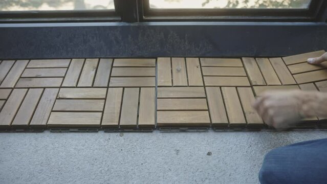 Crop View Of A Person Installing Interlocking Deck Tiles. Close Up