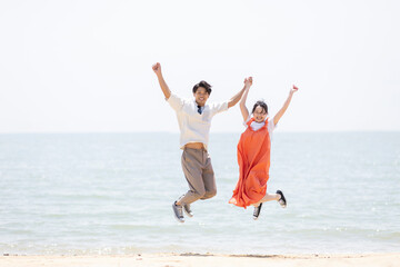 海辺でジャンプする男女