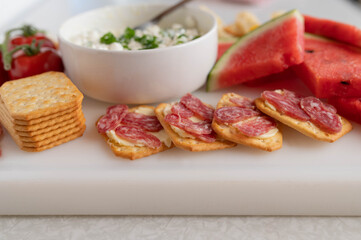 Watermelon appetizer with salami, cheese and crackers.