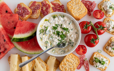 Appetizer with watermelon, cheese and crackers on white platter