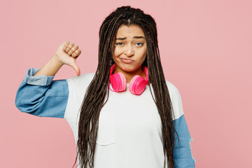 Young sad woman of African American ethnicity in white sweatshirt casual clothes headphones showing...