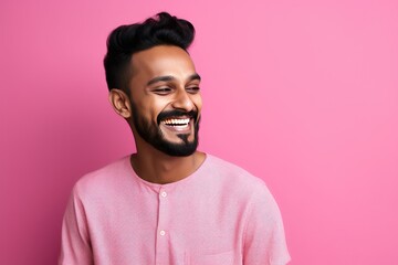 Obraz premium Handsome Indian guy laughing on pink background. Generative AI