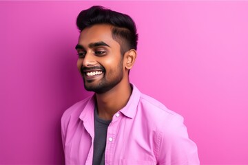 Obraz premium Handsome Indian guy laughing on pink background. Generative AI
