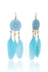 Subject shot of golden long boho style earrings decorated with openwork flowers and blue feather pendants. The earrings are isolated on the white background. Vogue accessory for ladies and girls.