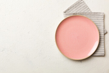 Top view on colored background empty round pink plate on tablecloth for food. Empty dish on napkin with space for your design