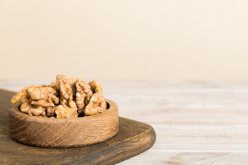 Fresh healthy walnuts in bowl on colored table background. Top view Healthy eating bertholletia concept. Super foods