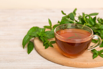 Cup of mint tea on table background. Green tea with fresh mint top view with copy space
