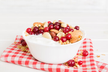 Healthy breakfast food with granola, yogurt, fruits and nuts. Dessert parfait with dried fruits for breakfast