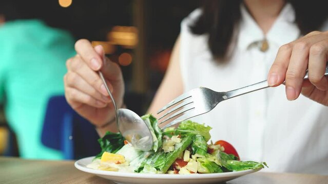 Woman eats vegetarian salad at restaurant. Healthy eating