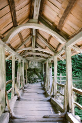 An ancient wooden bridge with a roof, view from inside the bridge.