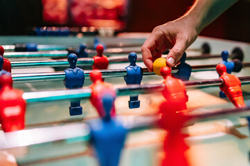 man plays table football. Detail of man's hands playing the kicker - obrazy, fototapety, plakaty