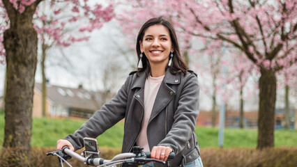 Close portrait of beautiful multi-ethnic Turkish woman 20-29s riding a bike in the city street