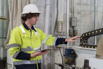 Male engineer worker checking conveyor belt machine at the industry factory. Male technician wear...