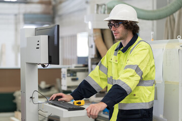 Male engineer worker working with laptop computer in industry factory. Male technician using laptop computer control and maintaining machine in the factory