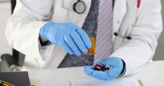 Doctor sitting at table and pouring many capsules from jar into hand 4k movie. Dietary supplement treatment concept