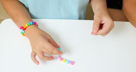 Process of making a bracelet from a thread and colored beads