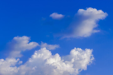 Naklejka na ściany i meble Group of white fluffy and soft clouds on blue sky. Background with copy space for meteorology presentation or natural and environment concept.
