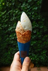 closeup maple waffle ice cream on hands with green leaf background