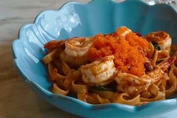 closeup spicy fried shrimp pasta on top with mentaiko