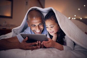 Father, kid and smile with tablet at night under blanket of online games, reading ebook or storytelling app. Happy dad, girl child or watch cartoon movie on digital tech, media or internet in bedroom