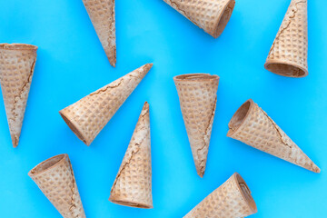 Empty ice cream cone on blue background.