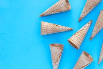 Empty ice cream cone on blue background.