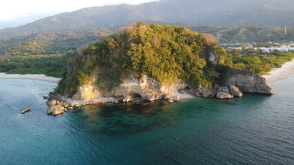 View of the sea and mountains. Stone cape and the sea. Aerial view of tropical island rocky promontory, jungle and calm sea.