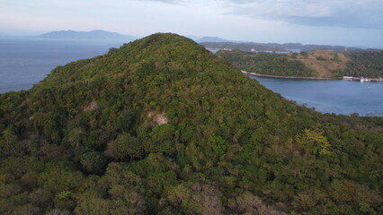 Fototapeta na wymiar View from the top of the mountain. Tropical landscape. Aerial view of a hill on a tropical island covered with tropical rainforest.
