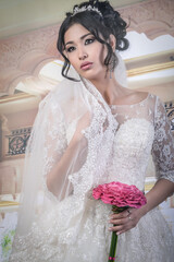 Romantic portrait with a girl in the image of a bride with a wedding bouquet