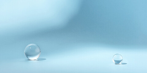Blue background with transparent glass balls. Minimal concept and soft sunlight.