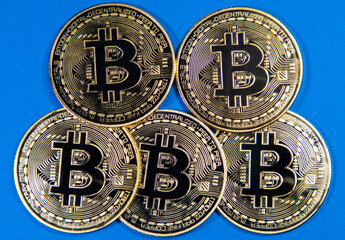 Bitcoin gold coins on blue background. Virtual cryptocurrency