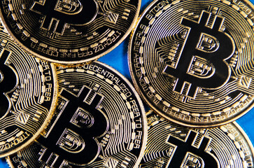 Fototapeta na wymiar Bitcoin gold coins on blue background. Virtual cryptocurrency