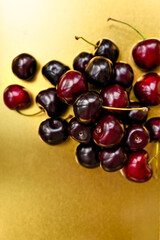 A handful of cherries against a golden background. Sweet red cherries. Cherries. fruit still life