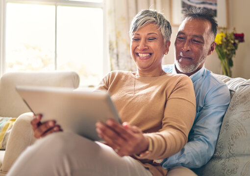 Happy, streaming and a couple with a tablet on the sofa for communication, social media or online chat. Smile, house and a senior man and woman with a movie on technology on the couch and laughing