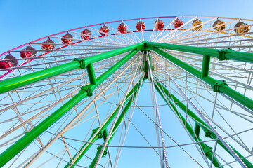 Ferris wheel on blue sky background . Amusement park ride