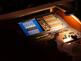 Digital audio mixing console illuminated by an incandescent lamp during a concert