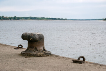 Old cast-iron bollard on the pier of the river pier