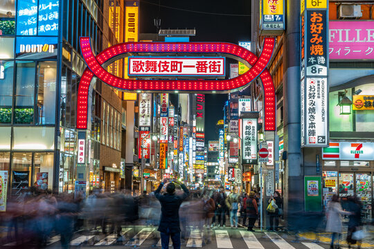 Tokyo - March 15, 2019 : Unidentified person making pictures and Motion blured people walking through the entrance of Kabukicho entertainment and Red Light district in Shinjuku Ward, Tokyo