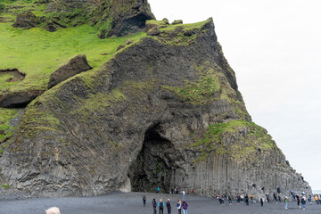Reynisfjara Black Sand Beach, Iceland - 06.22.2023: Tourists at basalt columns on Reynisfjara beach