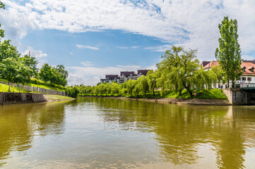 Obraz premium A view from underneath the Mortuary Bridge down the Ljubljanica River in Ljubljana, Slovenia in summertime