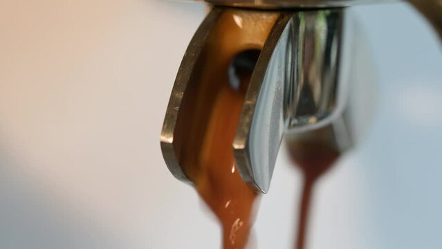 Nahaufnahme von frischem, hei&szlig;em Kaffee, Espresso, Crema l&auml;uft, flie&szlig;t aus der Espressomaschine. Die selektive Sch&auml;rfe liegt auf dem laufenden Kaffee