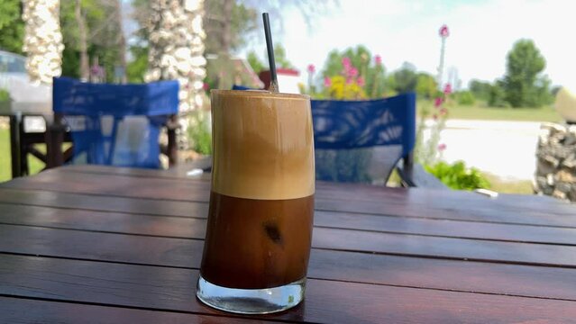 Close-up of freshly made Greek Frappe. Nescafe Frappe. Greek iced coffee drink made from instant coffee. Outdoor Greek coffee culture.