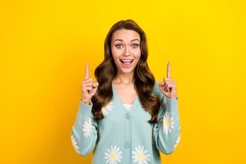 Photo of excited funky lady dressed teal cardigan open mouth pointing two fingers up emtpy space isolated yellow color background