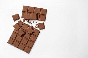 Delicious broken chocolate bar on white background, flat lay. Space for text
