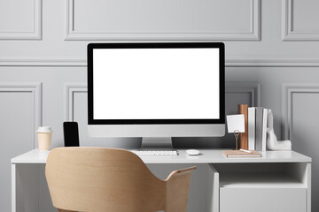 Cozy workspace with computer and stationery on white desk indoors. Interior design
