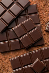 Delicious dark chocolate and cocoa powder on table, flat lay
